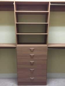 Brown Wardrobe having multiple shelves and drawer in a room